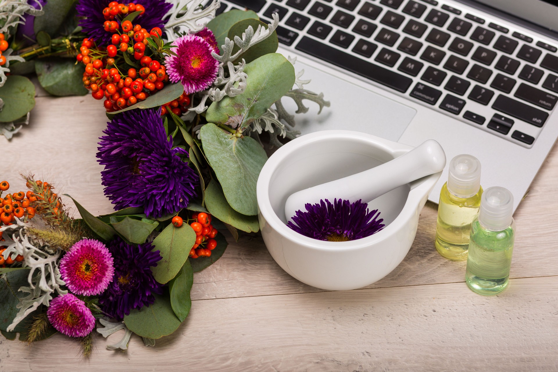 Seasonal skincare products with flowers on a wooden background