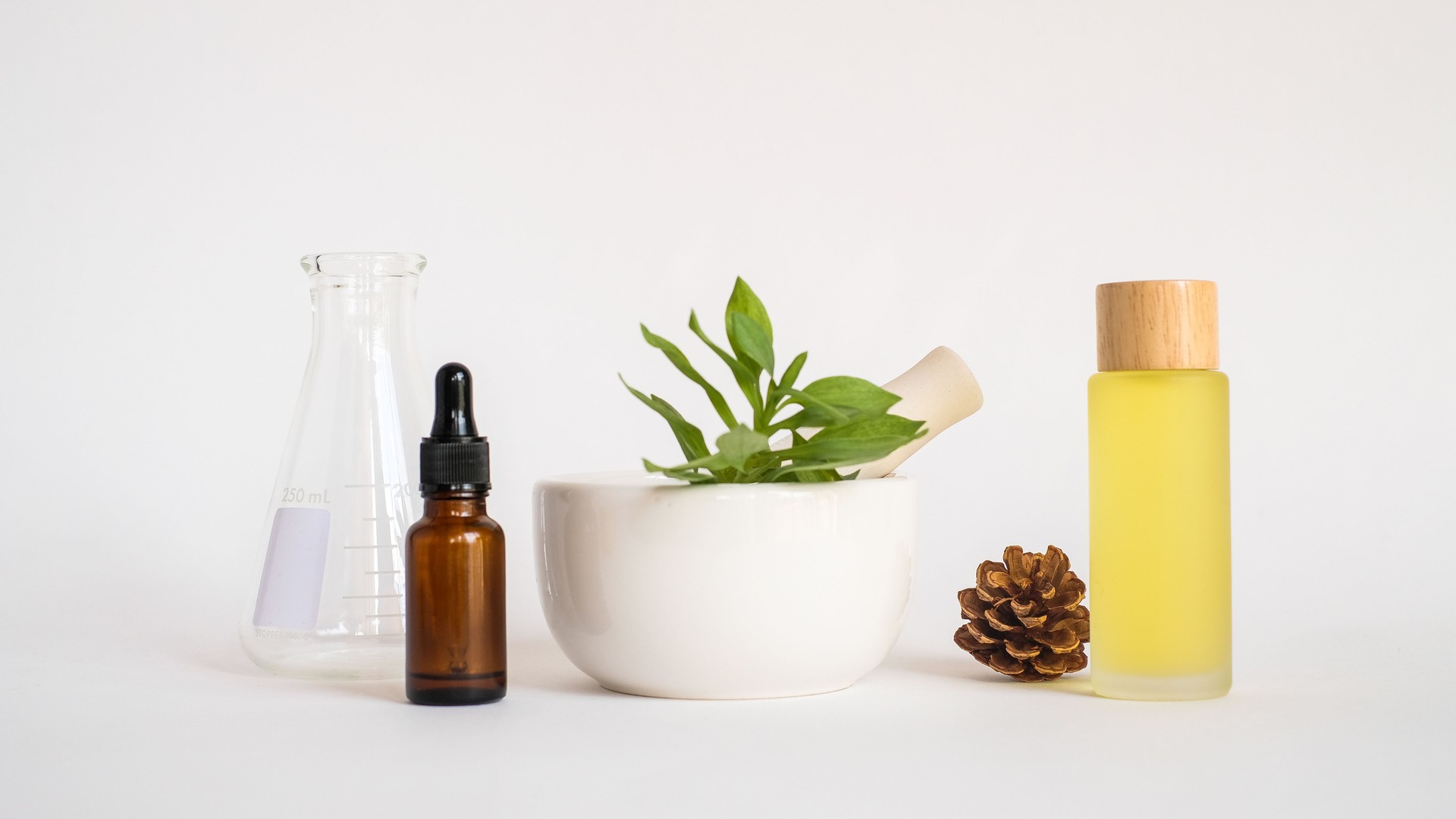 aromatherapy oil with mortar and natural green leaf on white background . aroma skin beauty spa product concept.